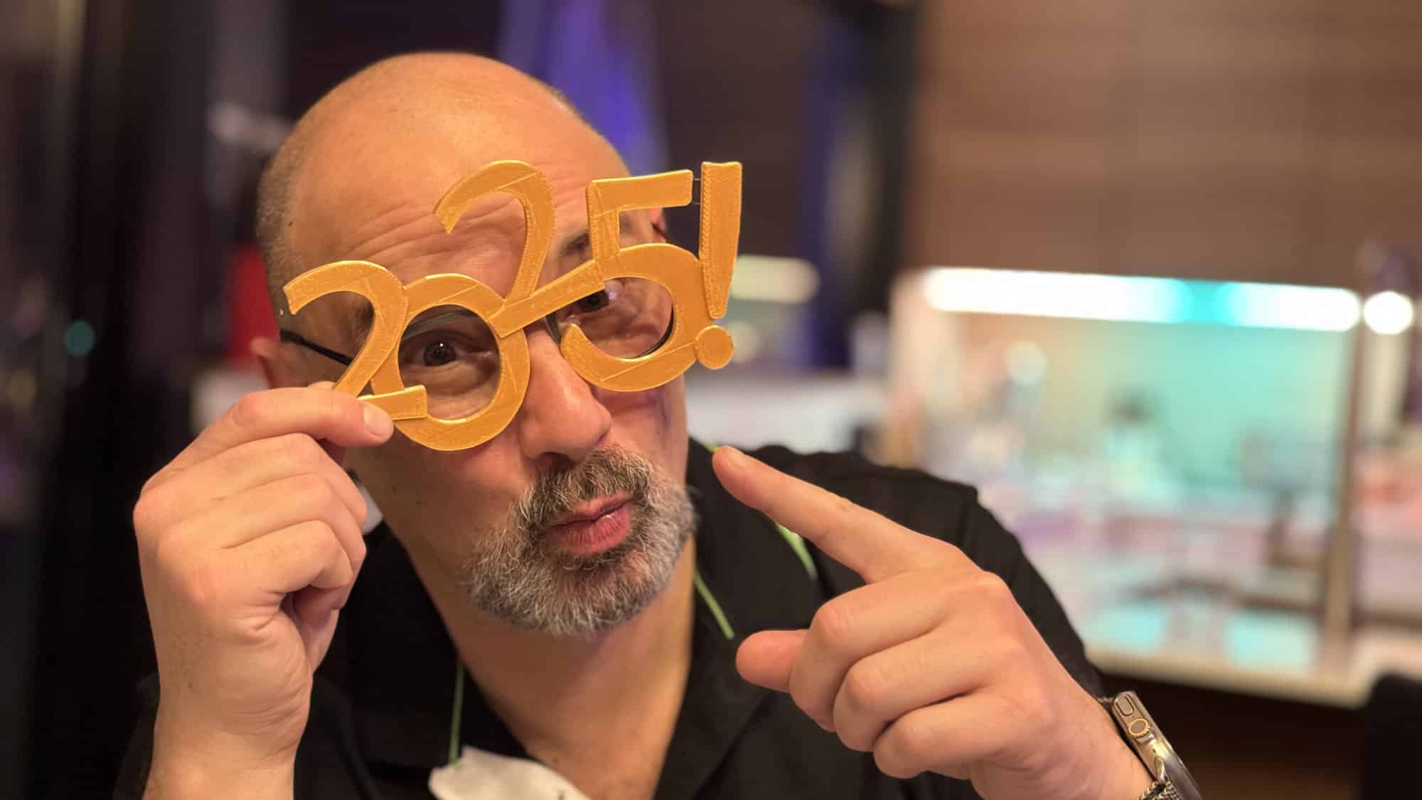Un homme portant des lunettes fantaisie en forme de « 2025 ».