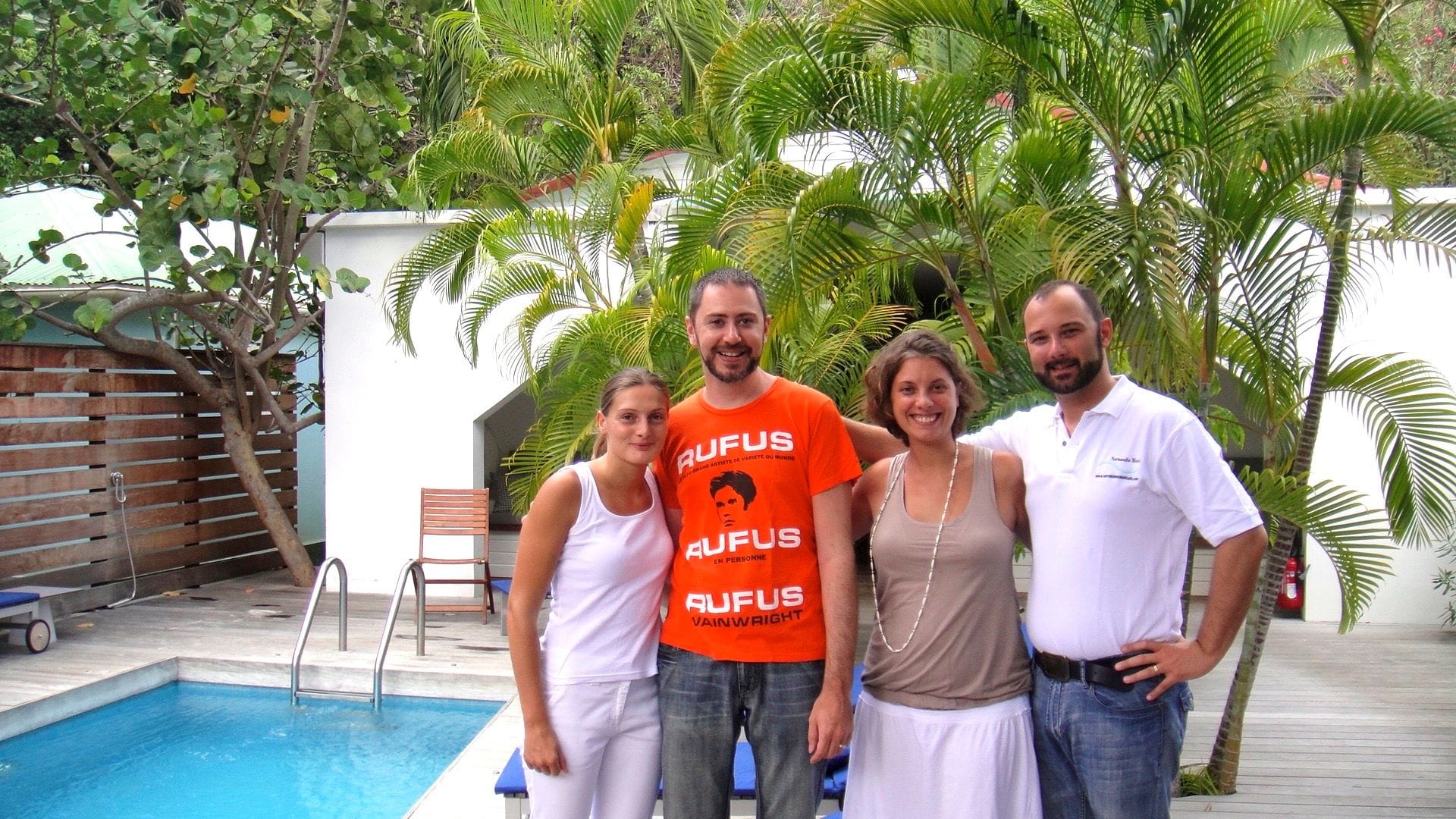 Quatre personnes réunies au bord de la piscine de l'hôtel.
