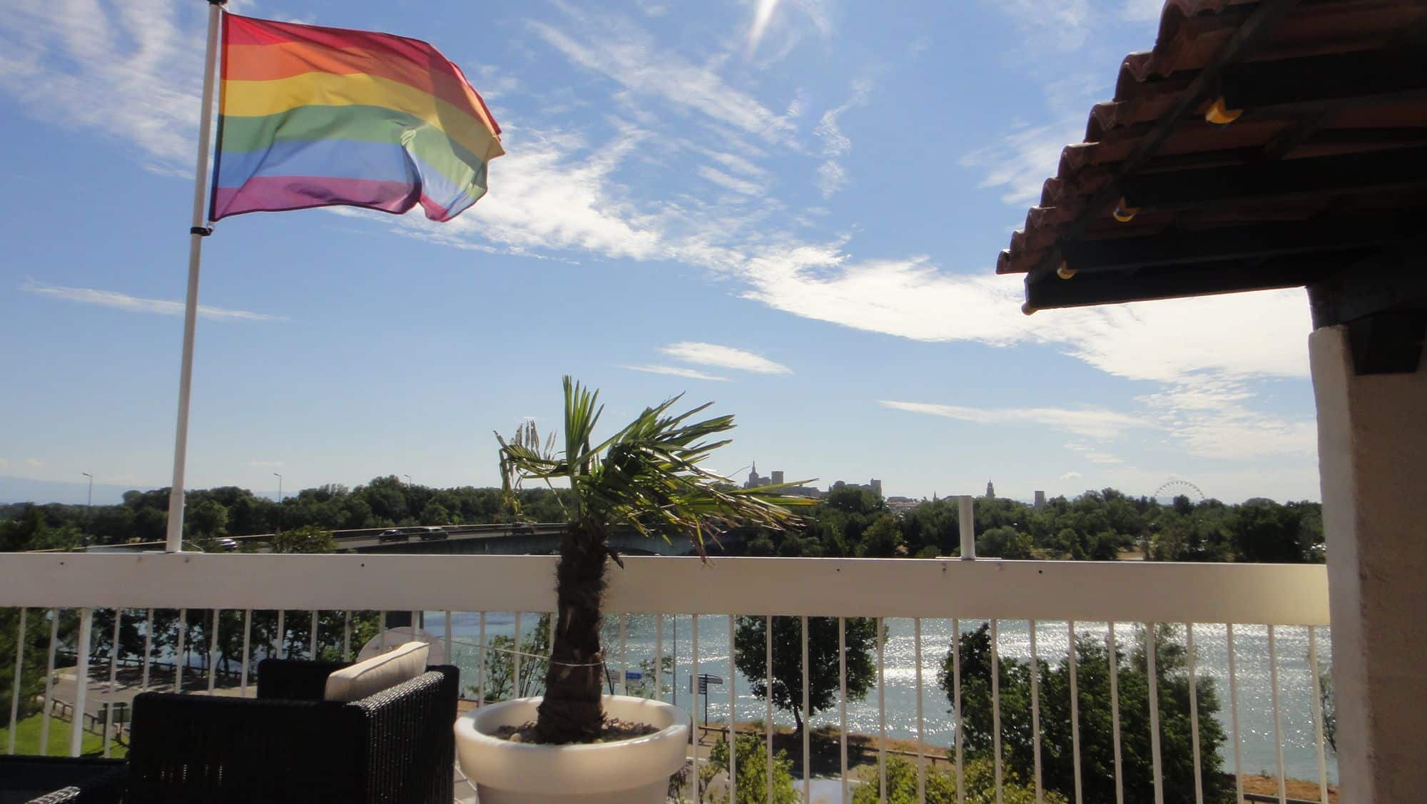 Un drapeau arc-en-ciel flotte au-dessus de la terrasse.
