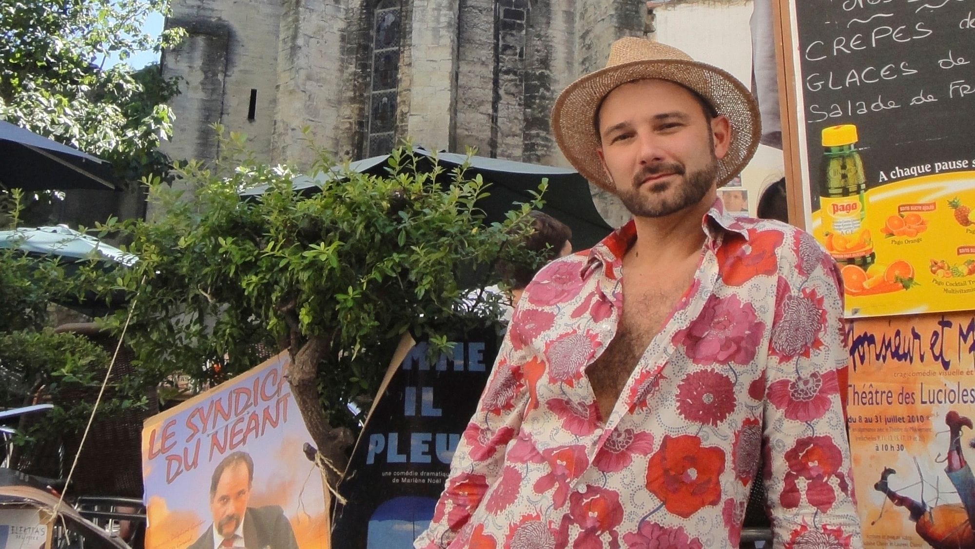 Un homme en chapeau de paille dans la rue du festival.
