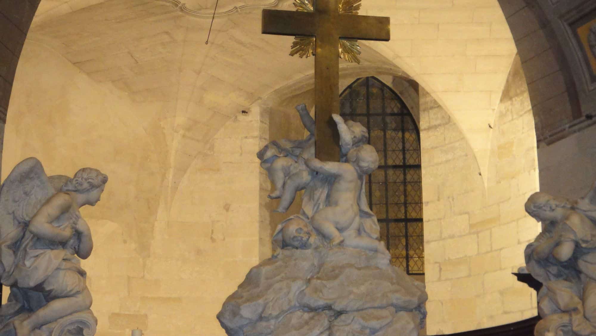 Un groupe sculpté surmonté d'une croix, sous les voûtes.