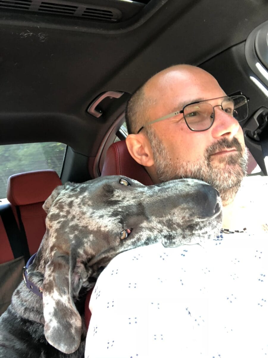 Roxane pose la tête sur l'épaule du conducteur, en voiture.